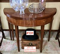 Front view of demilune table closed showing diamond inlay apron and tapered legs