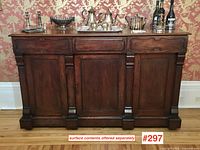 Front view of walnut sideboard buffet showing three drawers above three paneled doors.