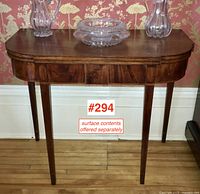 Full front view showing oval inlaid motifs and tapered legs