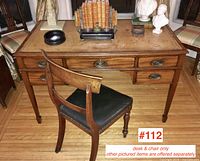 Front view of desk and chair showing leather inlay top, drawer layout and chair placement