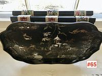 View of front of black lacquered tray showing gilt chinoiserie scene with abalone highlights