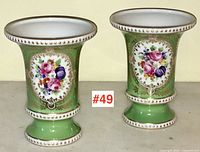 Pair of green Dresden porcelain vases shown side by side with front floral decoration visible