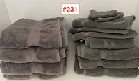 Full view of the set of 6 gray towels stacked neatly in two piles showing texture and band detail