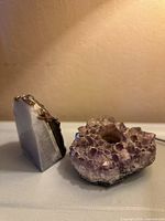 Polished agate slice and amethyst cluster together on a flat surface