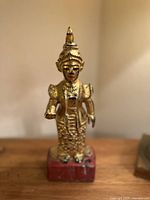 Front view of the gilt wood Burmese Nat statue showing detailed facial features and attire