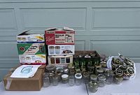 Full lot displayed on a table showing boxed and loose mason jars and canning jars