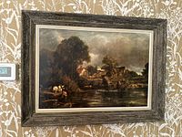 Framed art print of The Hay Wain hanging on wall, showing full view with rustic wooden frame.