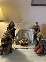 Full view of the nativity scene set showing figurines arranged around the stable backdrop