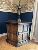 Hexagonal vintage solid maple end table with doors closed, showing wood grain, panel design, and metal door handles.