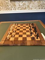 Wooden chess set showing side angle of chessboard and pieces arranged for play.