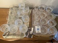 Top-down view of two trays holding 32 clear diamond-cut crystal glasses