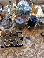 Overview of the complete ceramic dinnerware and glassware set spread out on a table, showing stacked plates, cups, and saucers in blue, white, and multi-color patterns.