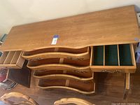 Top and front view of buffet showing the curved drawers, metal handles, and wooden dividers in the right side drawer.