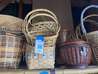 Photo capturing multiple wicker baskets of various natural shades along with a distinct red lidded wicker container, arranged on shelves to show the set's items and details.