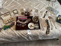Overall layout of mixed jewelry pieces on bed