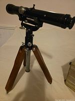 Spotting scope mounted on wooden-leg tripod