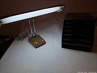 Desk lamp illuminated next to 6-slot organizer
