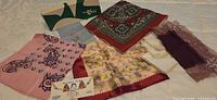 All items laid out including box, six scarves, two handkerchiefs and sweater grips