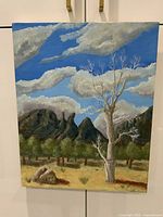Full view of oil on canvas landscape painting showing bare tree, rocky formations, cloudy blue sky, and foliage.