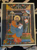 Full view of the framed religious icon enamel on metal showing the saint seated with scroll and halo with intricate colorful enamel detailing.