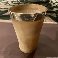 Cup with sterling silver rim showing hallmarks along the rim edge and visible natural body texture.