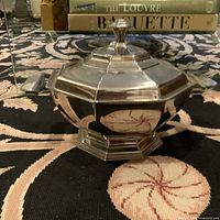 Closed view of vintage octagonal stainless steel covered serving dish with knobbed lid and handles