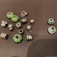 Overview of all glass and silver bracelet beads including green floral glass beads, silver charms and silver spacers