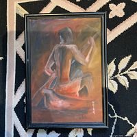 Photo of the framed original painting showing a person playing guitar from behind with warm color tones, signed by the artist.