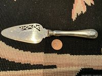 Full view of BIRKS sterling silver cake server with 925 mark and monogram. Shows ornate pierced details and engraved floral patterns on blade.
