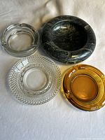 Top view of all four ashtrays showing materials and colors.