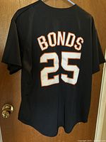 Back view of black jersey showing BONDS 25 embroidered in white with orange outline.