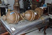 Three matching metal hanging lanterns laid on a table, showing full shape and vintage punched pattern details.