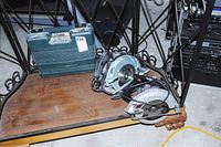 Photo showing Hitachi electric drill case and both circular saws on wooden shelf