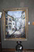Full view of the oil painting in heavily decorated frame, showing the Italian themed street scene.