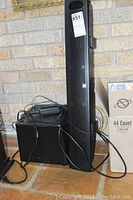 Full view of Boston sound bar system including sound bar speaker, subwoofer, and power adapter with cords.