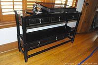 Front view of black side table showing six drawers and two shelves