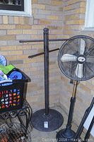 Full side view of the towel rack showing four horizontal arms and part of surrounding items.