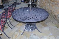 Top view showing the round metal table surface with lattice pattern and umbrella hole.