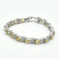Silver rhodium plated bracelet displayed in a circular form showing clasp and design details.