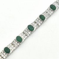 Close-up of the green onyx stones set in silver-colored rhodium plated bracelet with surrounding cubic zirconia stones.