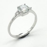 Close-up front view of silver ring with round moissanite gemstone and rhodium plating