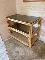 View of the bamboo and glass side table showing its glass top and bamboo frame structure.