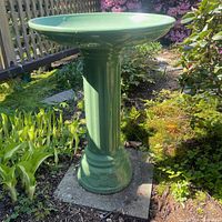 Full view of green glazed ceramic bird bath outdoors