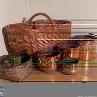 Overview of the lot showing a range of copper buckets, woven basket with moss, and a wicker basket in background.