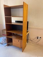 Full view of assembled three-piece teak shelving unit at slight angle