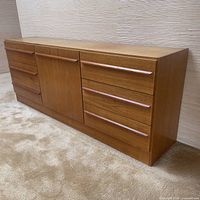 Front view of teak sideboard dresser showing three drawers on each side and central cabinet door.