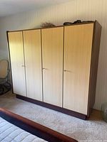 Front view of wardrobe with four lockable doors and two-tone wood veneer finish