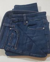 Front view of folded dark blue Buffalo David Bitton Aubrey jeans showing pocket and rivet details