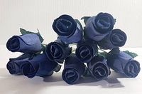 Top view showing twelve navy blue wooden roses tightly grouped with visible petals and fabric leaves.