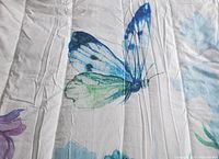 Close-up photo showing the multicolour butterfly print on the white comforter fabric.